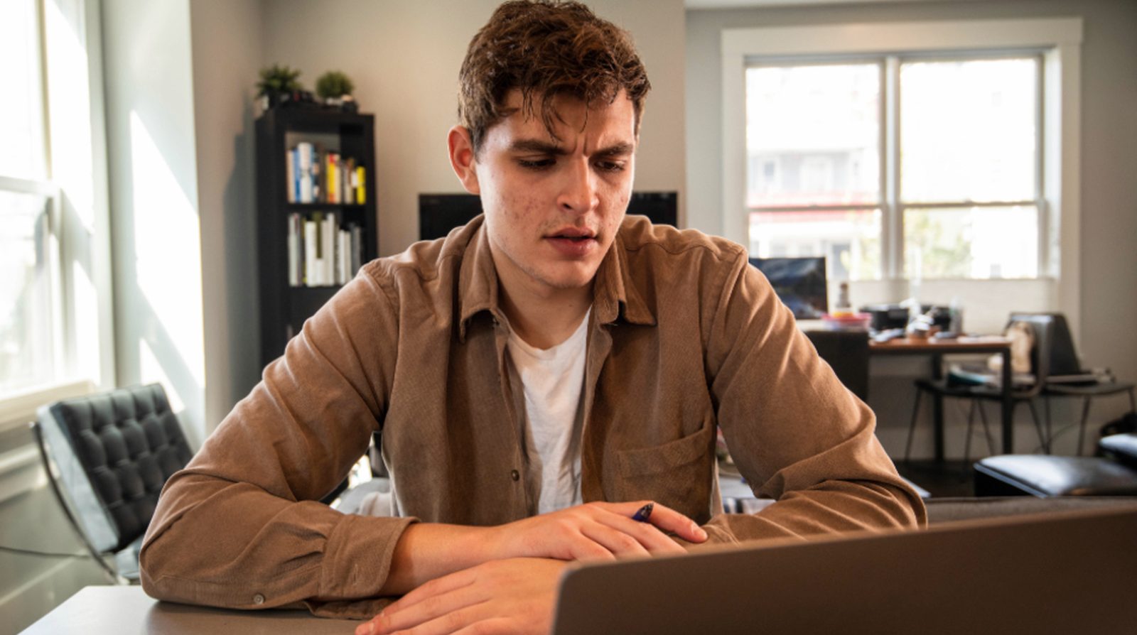 A person reading and configuring at a laptop